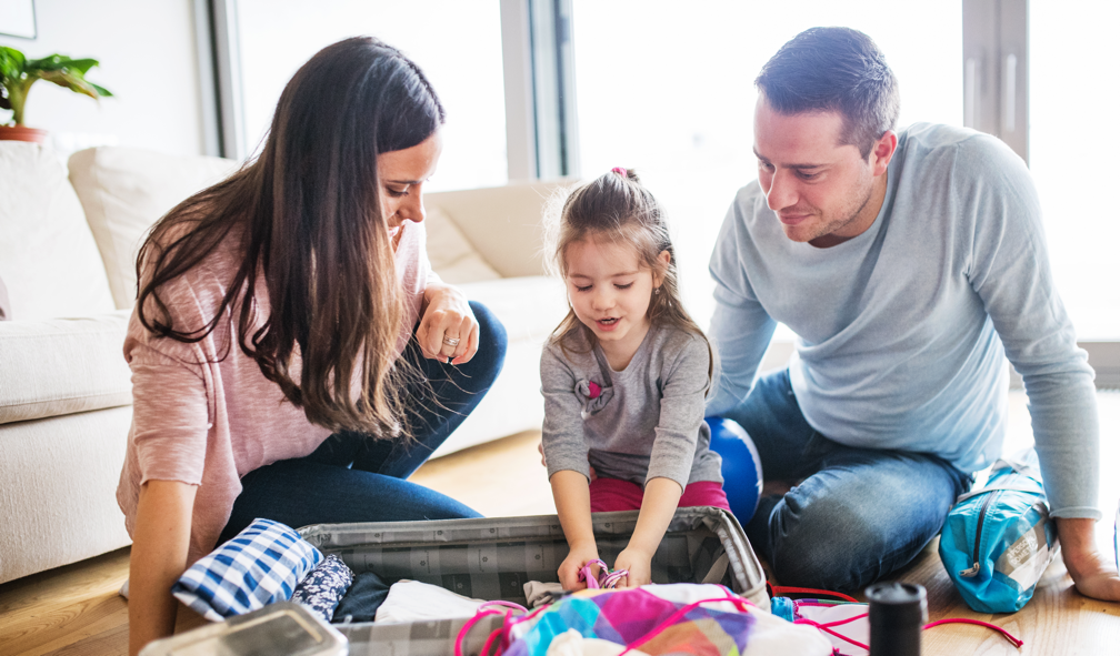 young-family-with-a-child-packing-for-holiday-PJ2RQCG