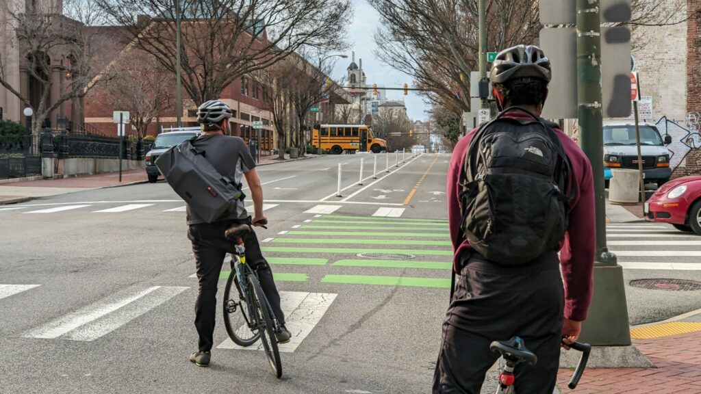 Two cyclists commute through downtown Richmond, Virginia using new dedicated bike lanes.