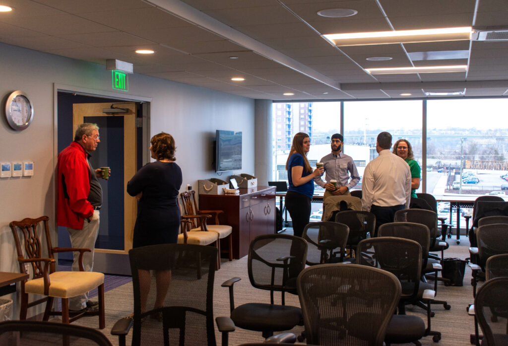 Guests networking in a meeting room during the First Look event at the new PlanRVA office space. 